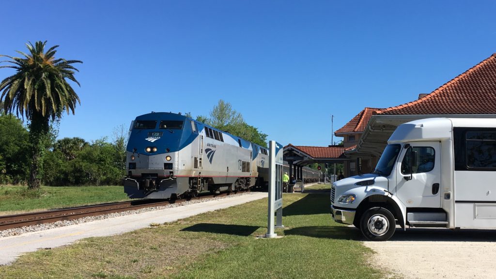 Photo of an Amtrak train and paratransit vehicle